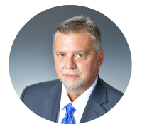 Headshot of Kentucky Farmers Bank SVP/ investments manager smirking, wearing a suit and blue tie against a grey background.